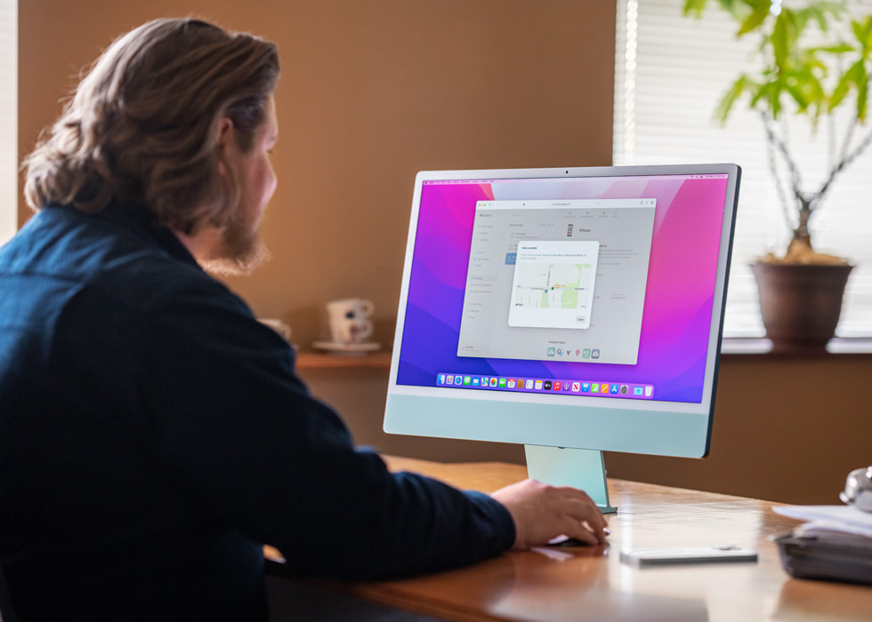 A customer sitting on his desk using Managed Lost Mode with Apple Business Essentials on an iMac.