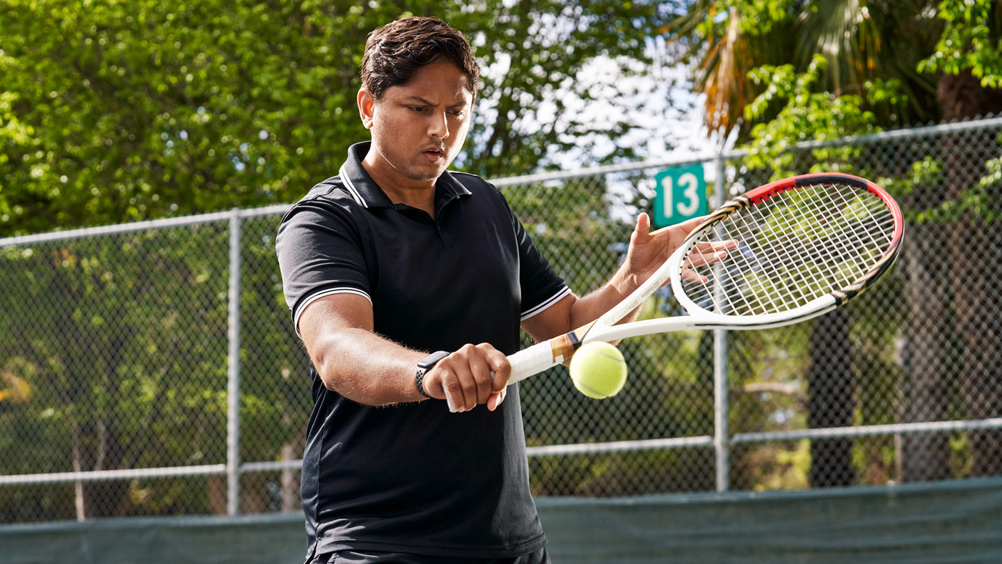 Sahai 在網球場上反手擊球。