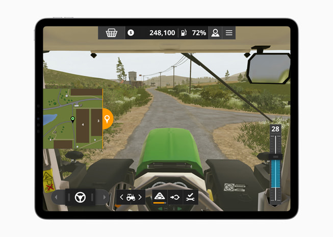 På en iPad Pro visas en stillbild av en traktor på en bondgård från spelet Farming Simulator 20+.