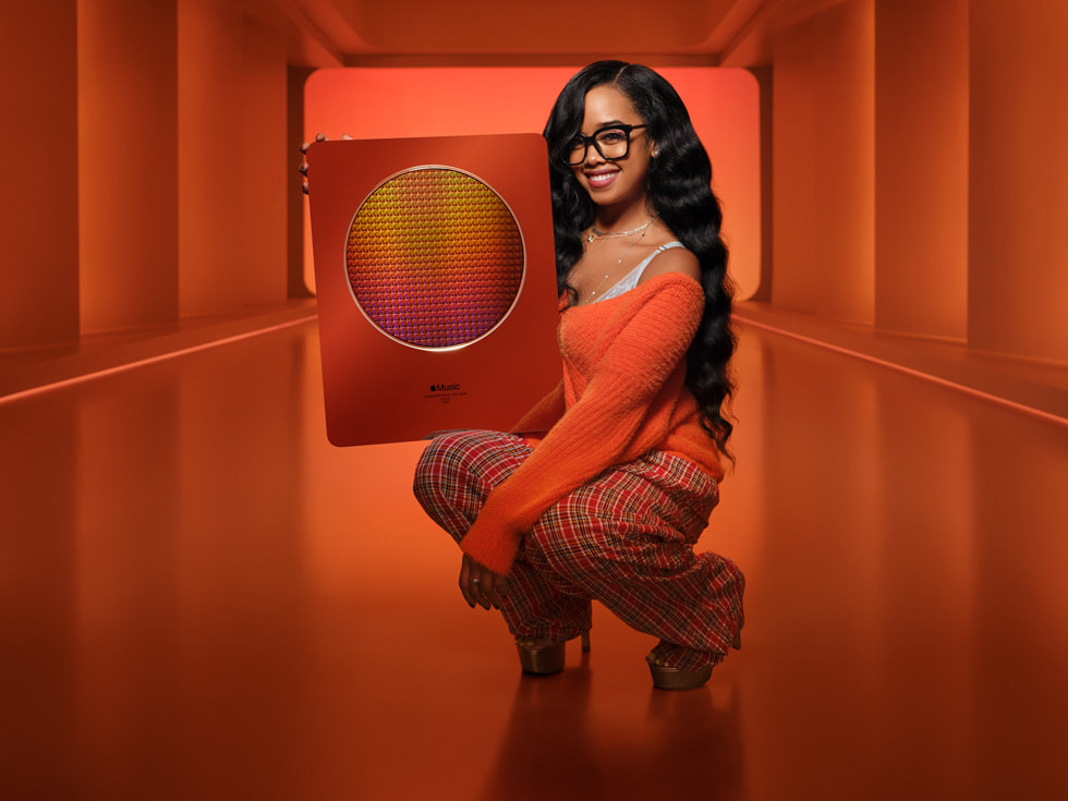 Musician H.E.R. poses with an Apple Music Award.