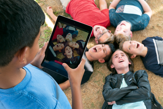 iPad를 사용해 같은 반 친구들의 사진을 찍는 학생.