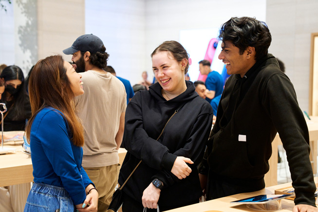 Apple 團隊成員和顧客在 Apple 零售店中交流。