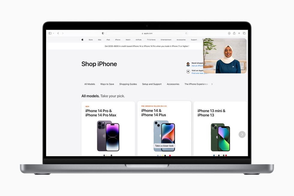 The Shop with a Specialist over Video experience is shown over an [apple.com] (https://www.apple.com) page reading “Compare iPhone models” and showing iPhone 14 Pro Max, iPhone 14 Plus and iPhone 14.