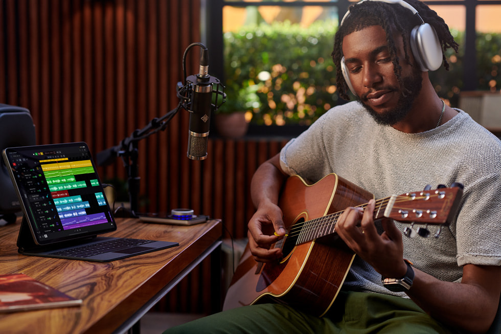 A person records themself playing guitar while using Logic Pro for iPad.