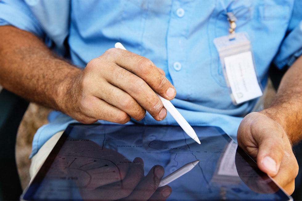 Een close-up van de handen van Rogers die met een Apple Pencil iets op een iPad Pro tekent.