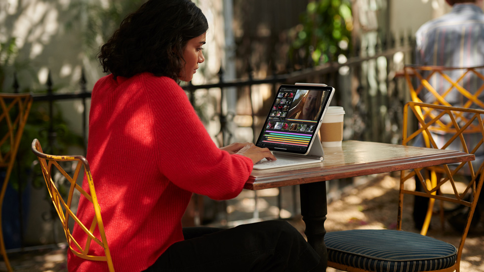 A woman using iPad Pro with the White Magic Keyboard. 