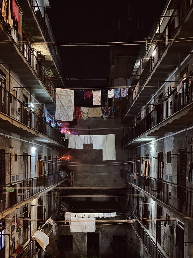 Laundry hanging on clotheslines between apartment buildings.