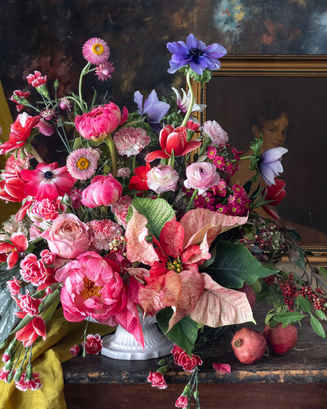 Floral arrangement set in front of a framed painting.