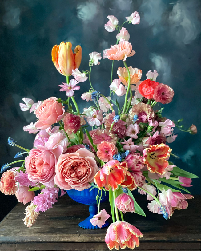 Des fleurs dans un vase bleu, photographiées avec le mode Portrait.