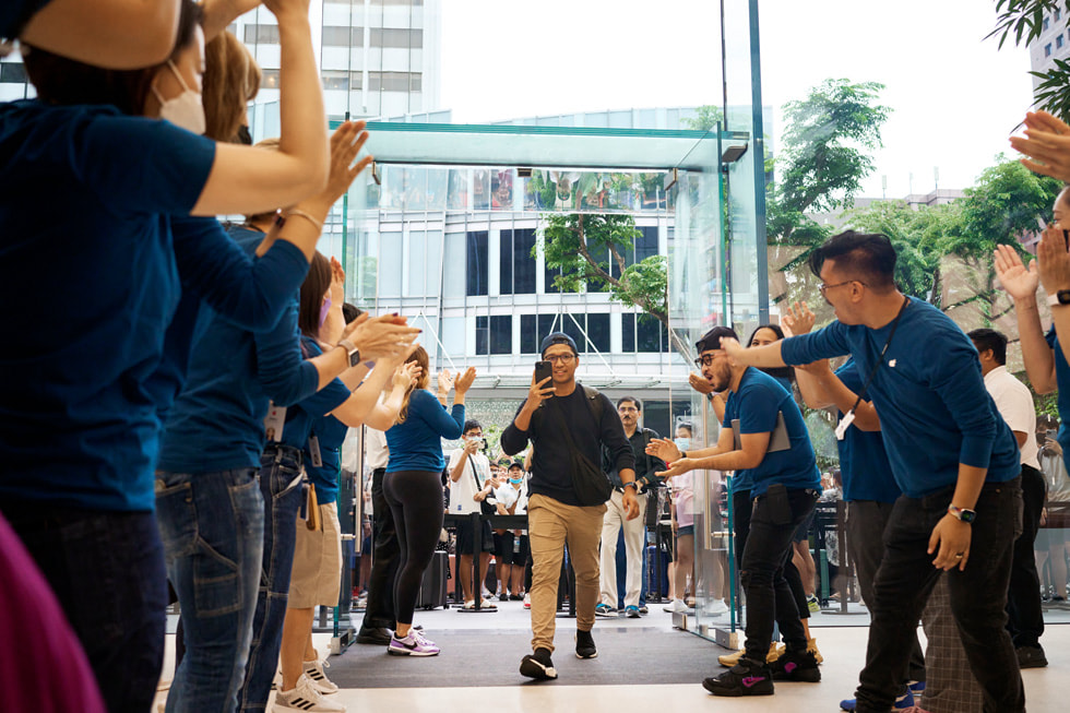 Les membres de l’équipe d’Apple Orchard Road applaudissent un client qui entre dans le magasin.