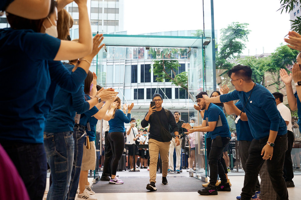 El equipo de Apple Orchard Road aplaude mientras un cliente entra en la tienda.