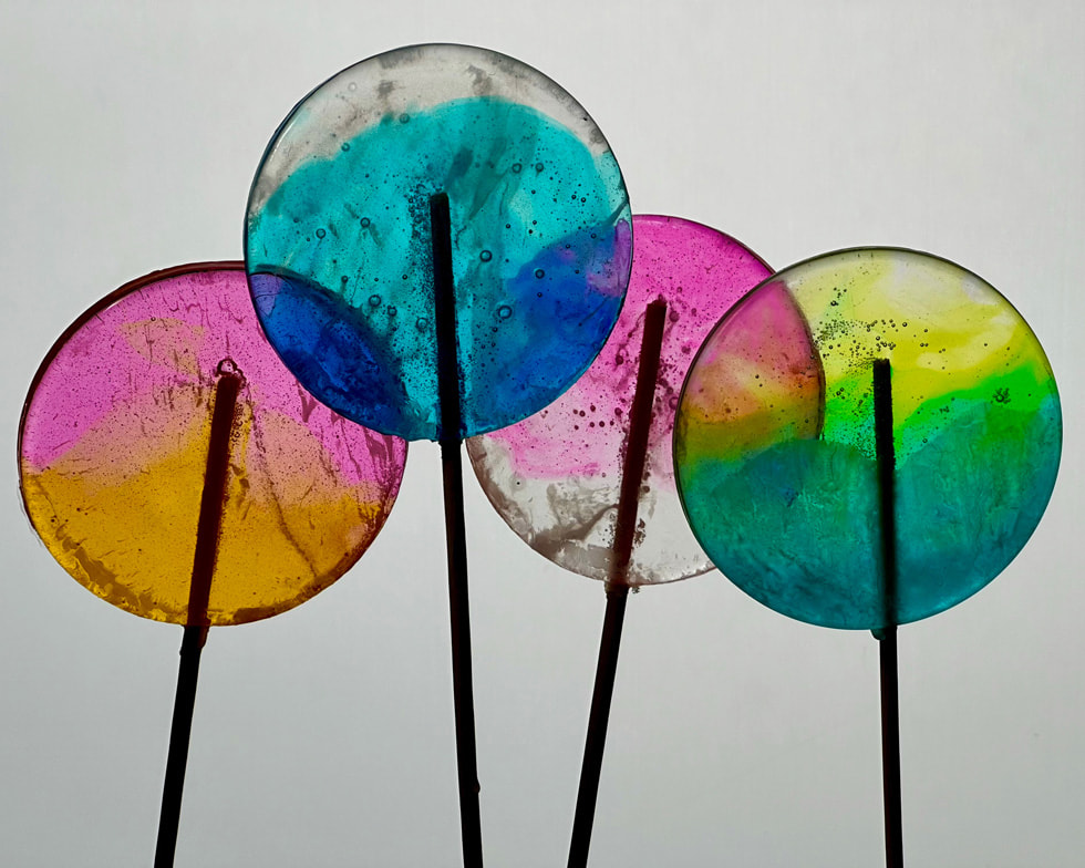 Four colourful lollipops are shot in close-up.