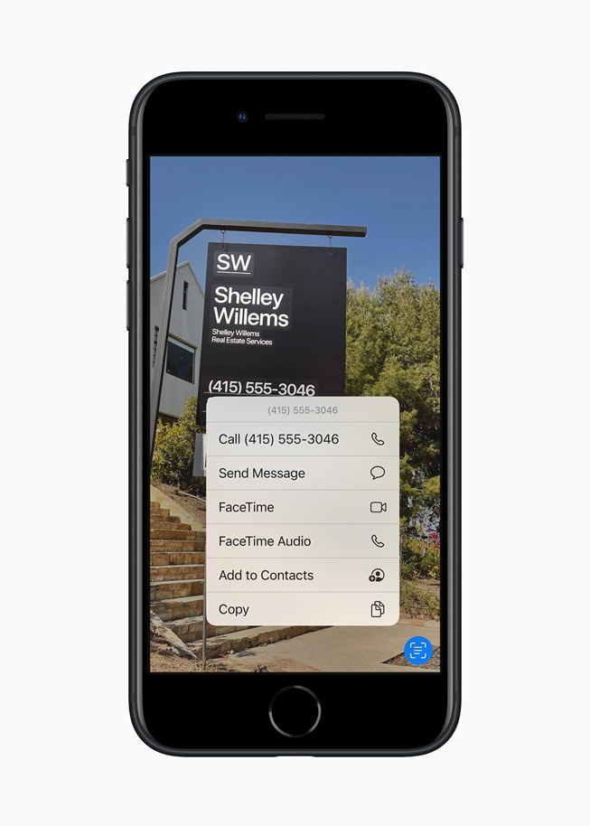 全新午夜色 iPhone SE 以 iOS 15 的「原況文字」功能辨識房屋標售板上的資訊。