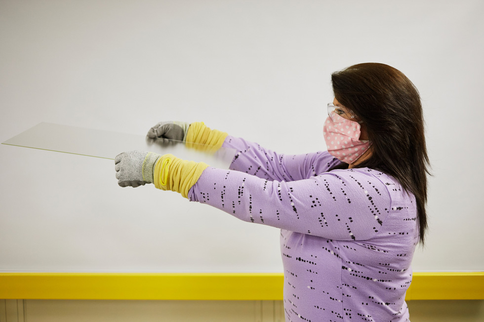 A glass technician inspecting a sheet of glass at the Corning plant in Harrodsburg, Kentucky.