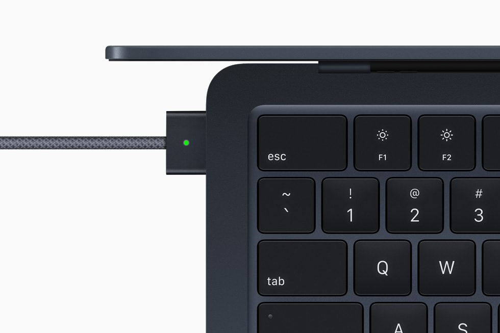Närbild av MagSafe-adaptern ansluten till MacBook Air i midnatt.