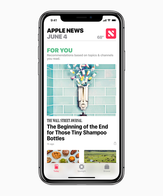 iPhone X showing Apple News app with For You recommendations.
