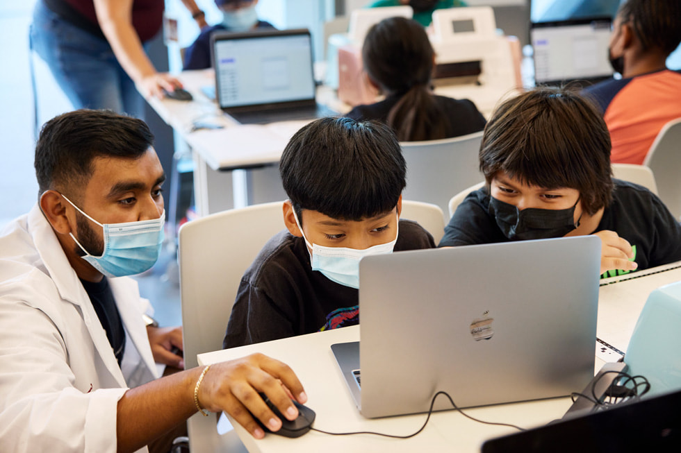 CSUDH 컴퓨터 실습실에서 강사의 도움을 받고 있는 두 명의 학생.