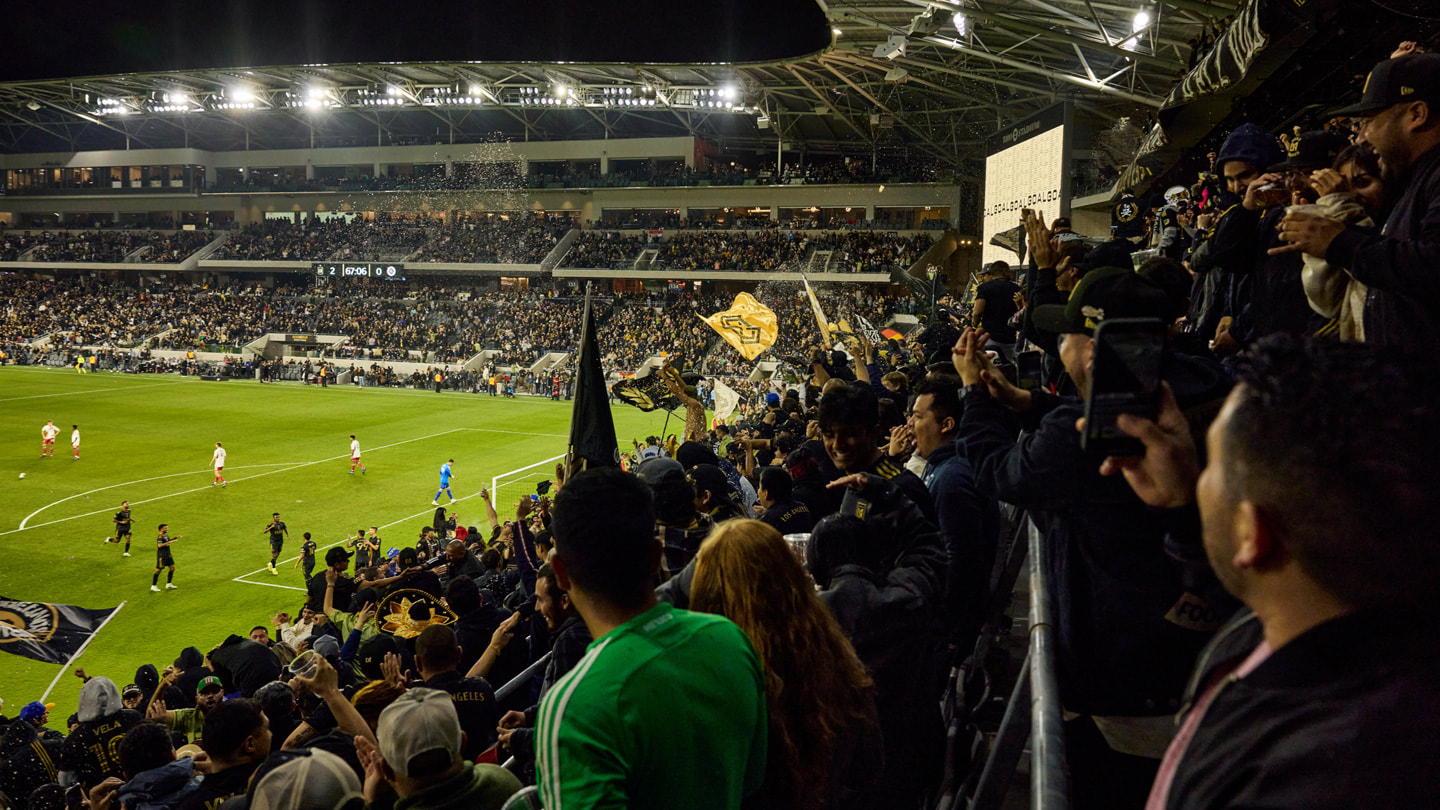 Fans of LAFC and the New England Revolution cheer for their clubs at BMO Stadium in Los Angeles. 