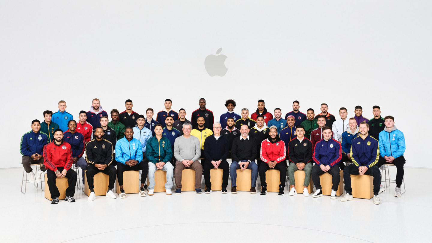 Group photo of MLS players with Tim Cook, Eddy Cue, and Don Garber inside Steve Jobs Theater at Apple Park.
