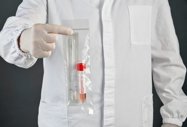 A COPAN Diagnostics lab technician holding a sample collection tube and swabs.