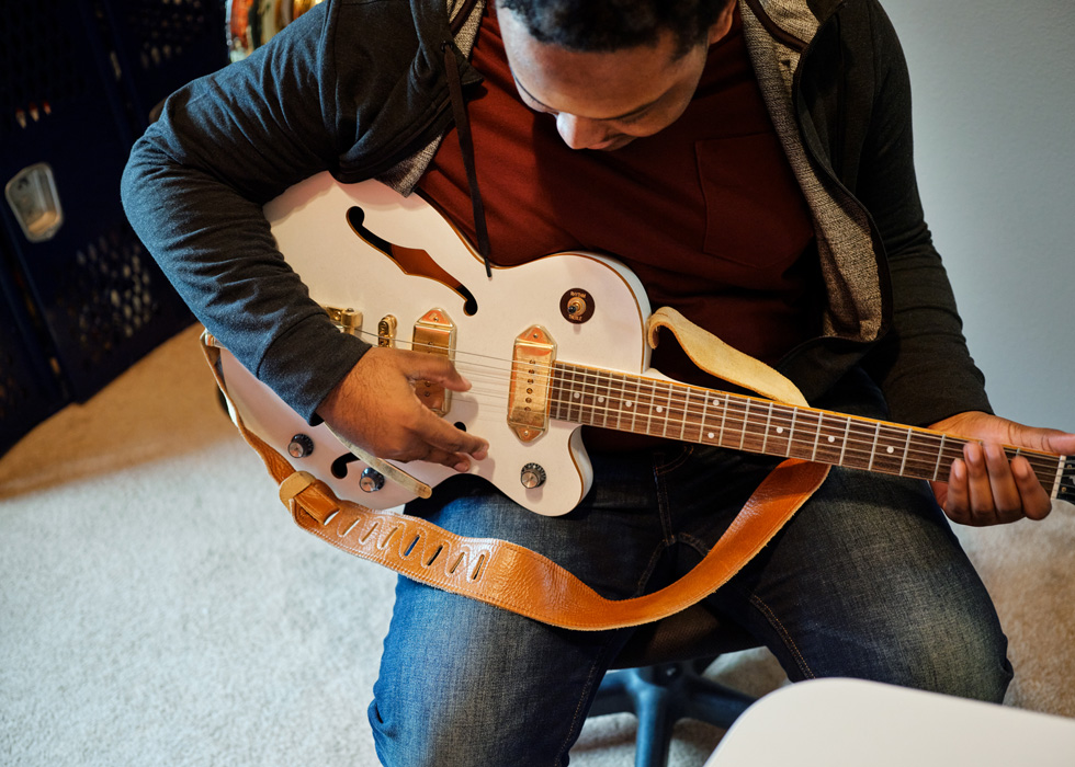 Rhys Richard practices guitar.