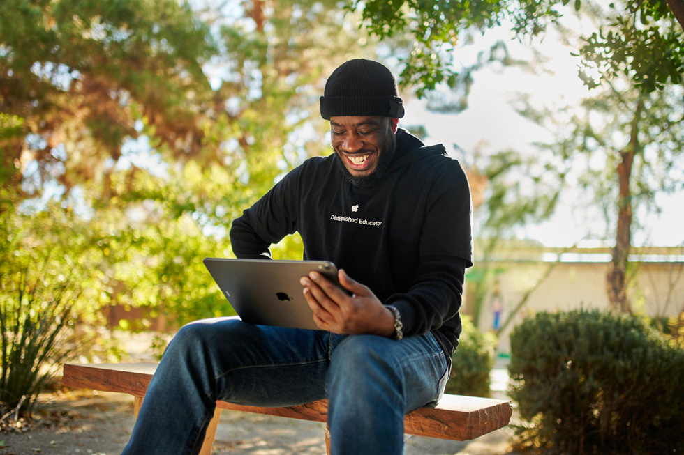 Mike Lang sentado en un jardín con un iPad.