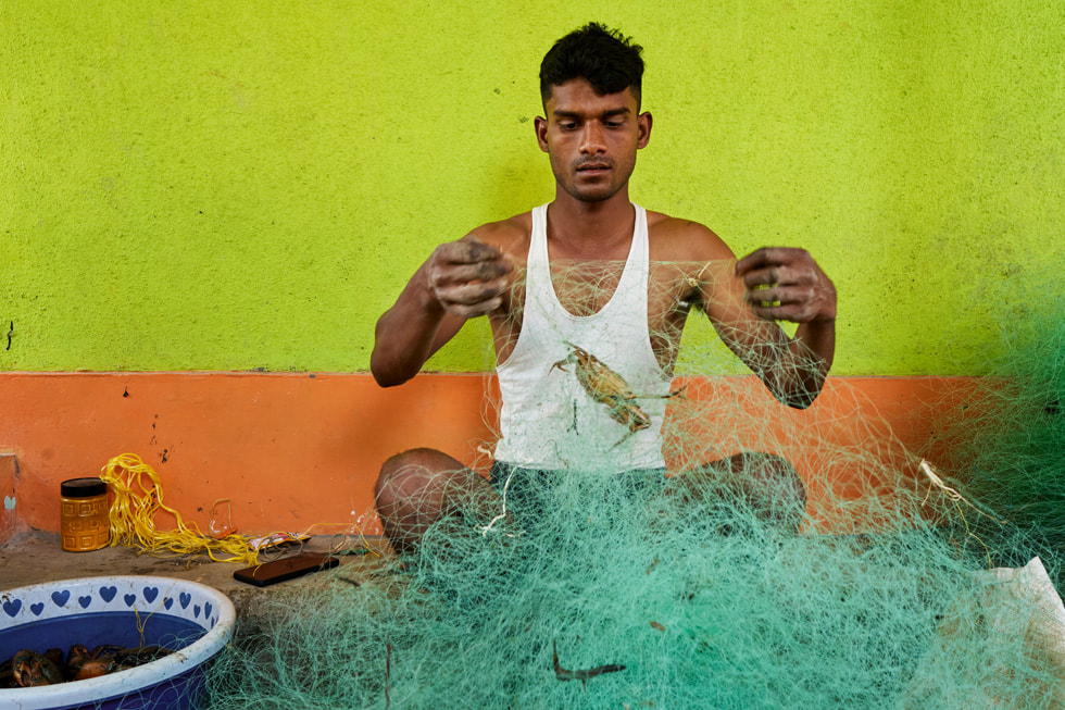 En fisker undersøker et fiskegarn i Indias Raigad-distrikt.