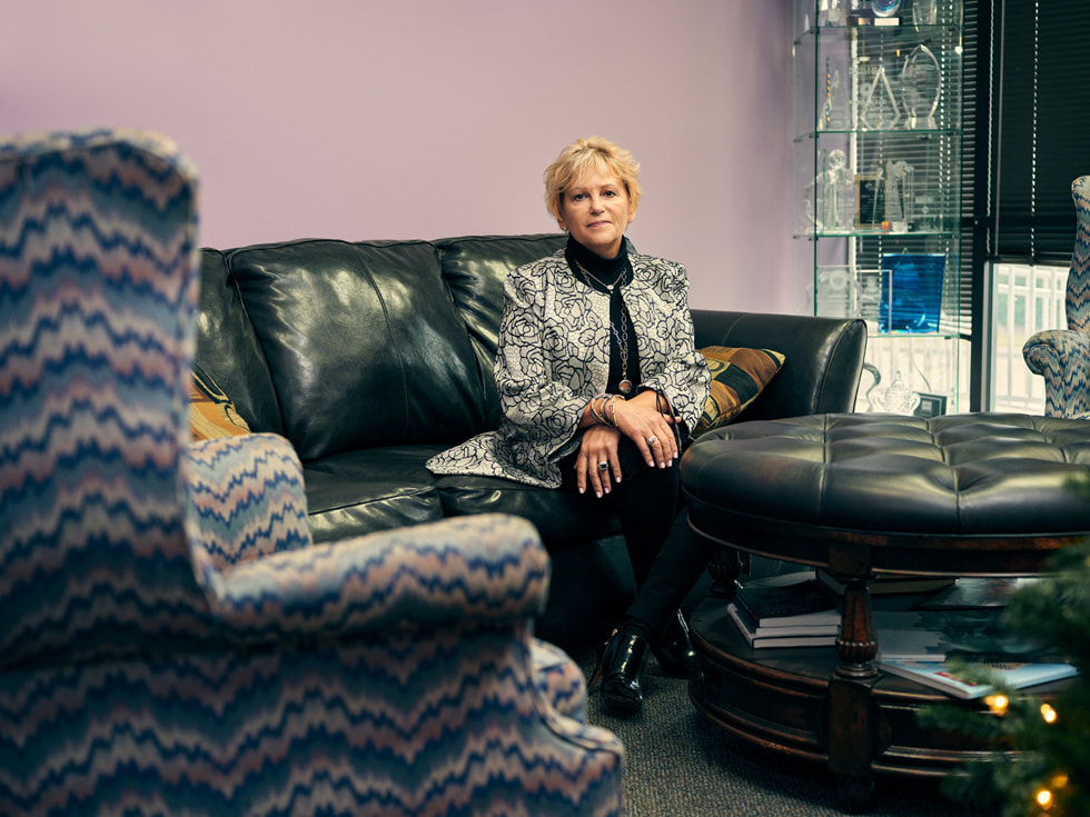 Betty Manetta, Argent Associates' president and CEO, sitting on a couch inside her office.