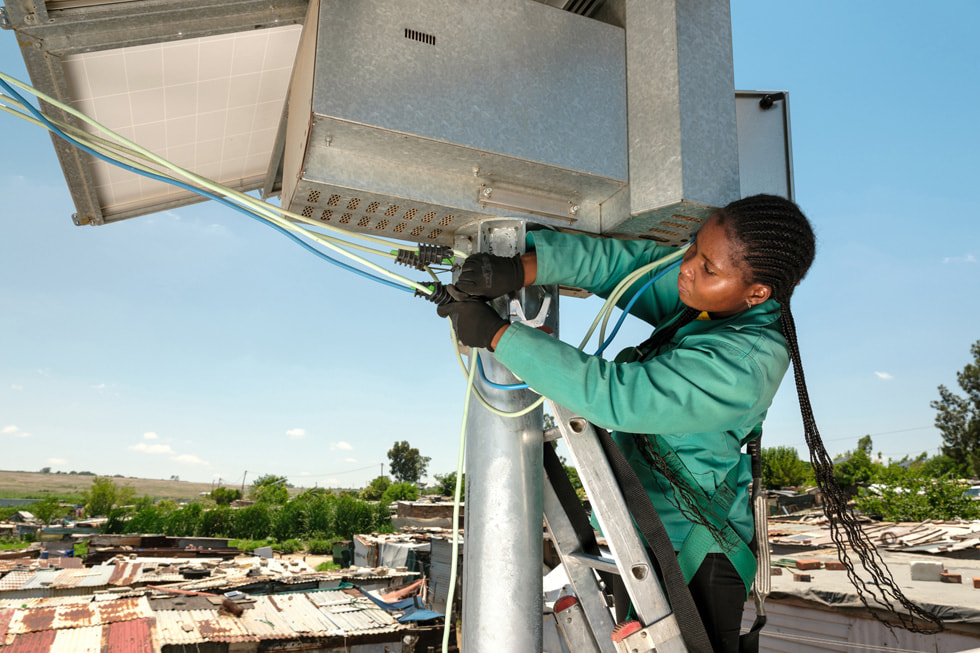 Instalación de un panel solar en lo alto de un poste en el municipio de Diepsloot, en Sudáfrica.