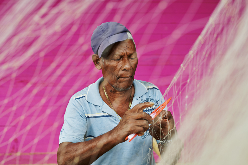 A fisherman in San Antero hand-weaves a fishing net.