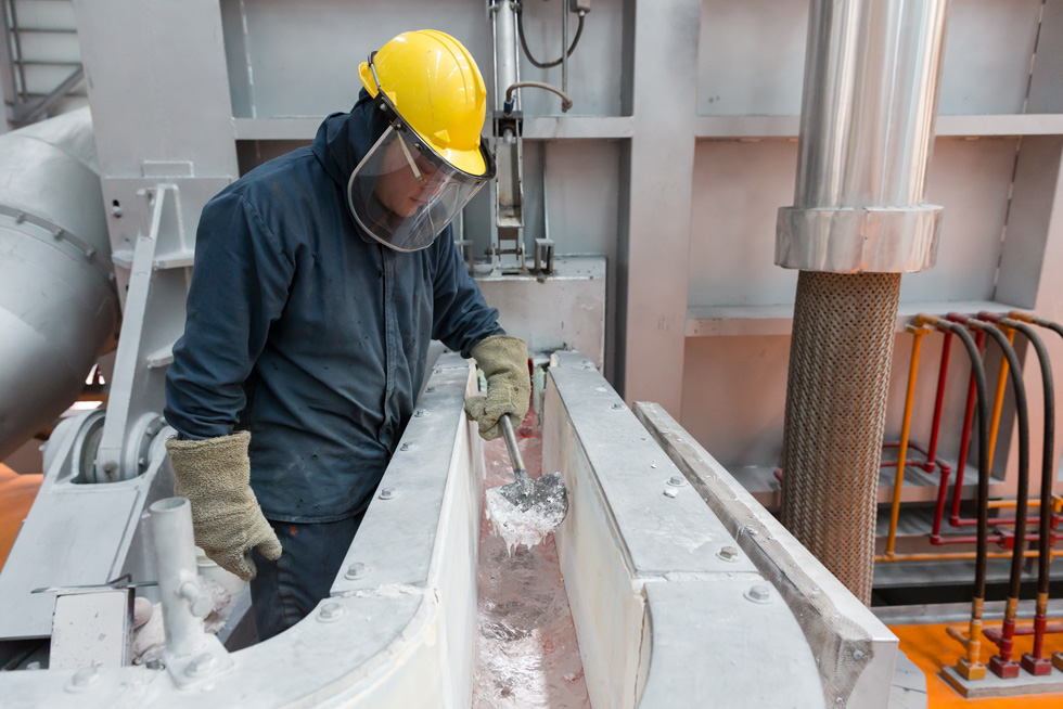 En arbetare övervakar smältningsprocessen på en aluminiumfabrik.