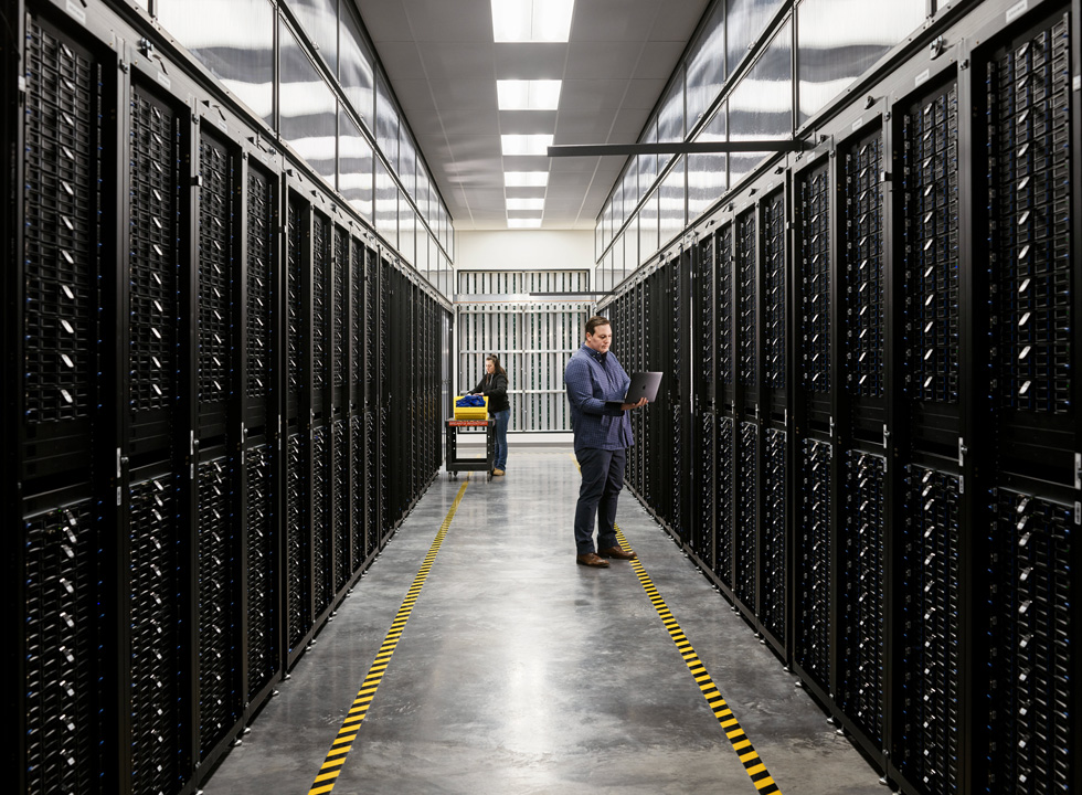 Dos empleados en la sala de servidores de un centro de datos de Apple.