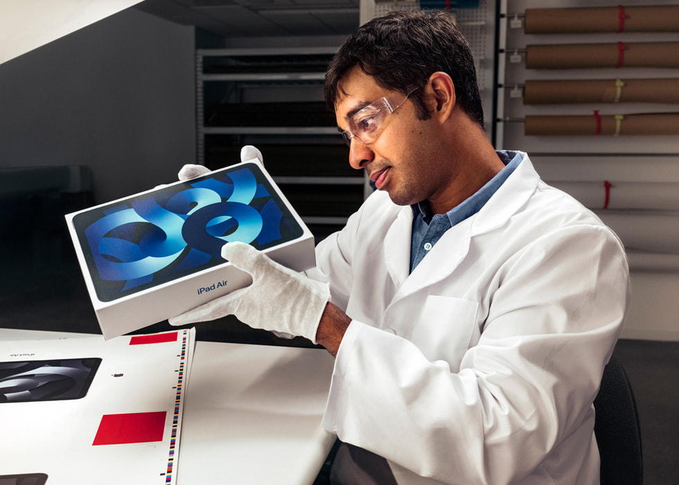 A technician inspecting iPad Air packaging. 