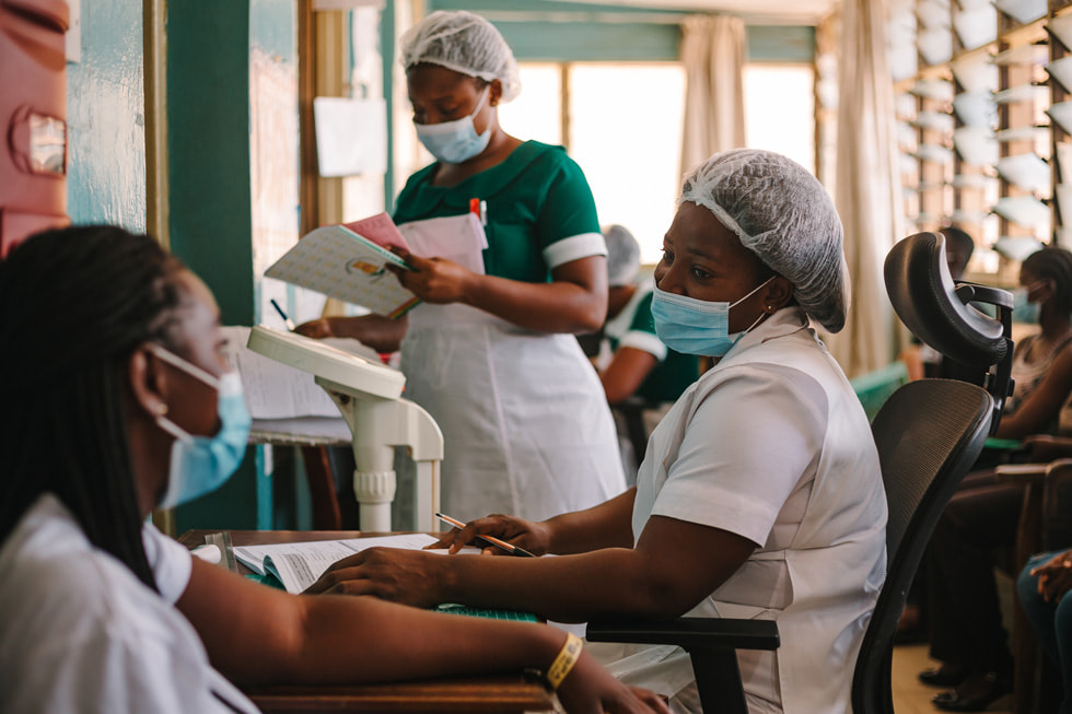 범세계 기금의 코로나19 대응 활동의 일환으로 임상 환경에서 환자와 이야기를 나누는 간호사들