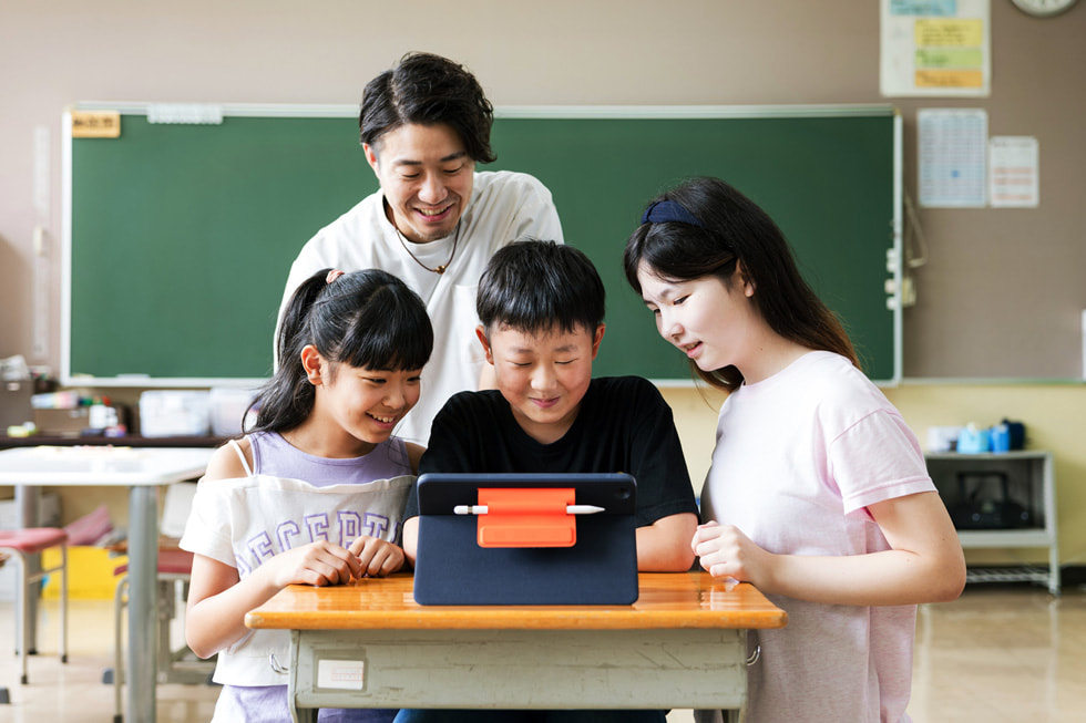 日本の教室で、3人の児童と指導者がiPadとApple Pencilを使っているところ。