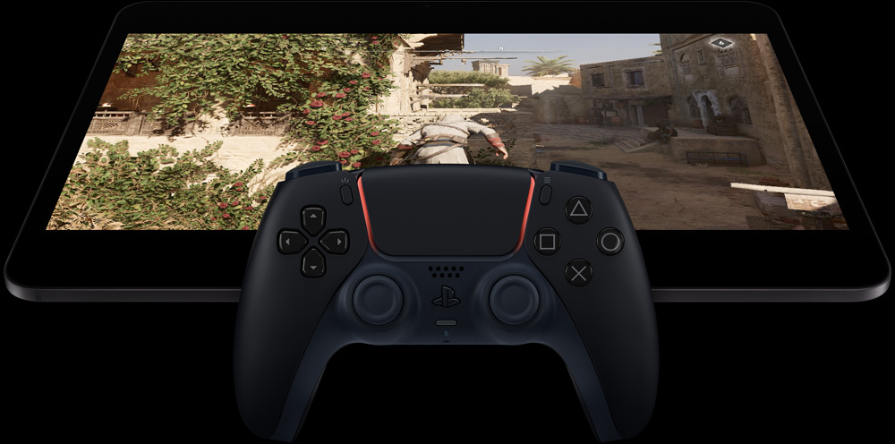 iPad Pro în dispunere orizontală, ecranul arată un joc video, un controler PlayStation în fața iPad-ului