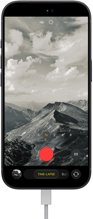 iPhone 18 Pro, exterior frontal, cu un peisaj montan pe ecran, cu modul camerei setat pe Time-Lapse, cu cablu de alimentare atașat la portul de încărcare