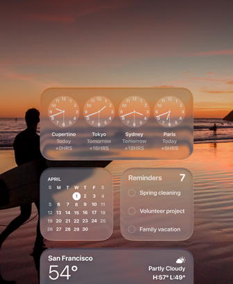 Liquid Glass Clock, Calendar, Reminders, and Weather widgets on macOS Tahoe screen over a scene of a surfer walking on the beach at sunset