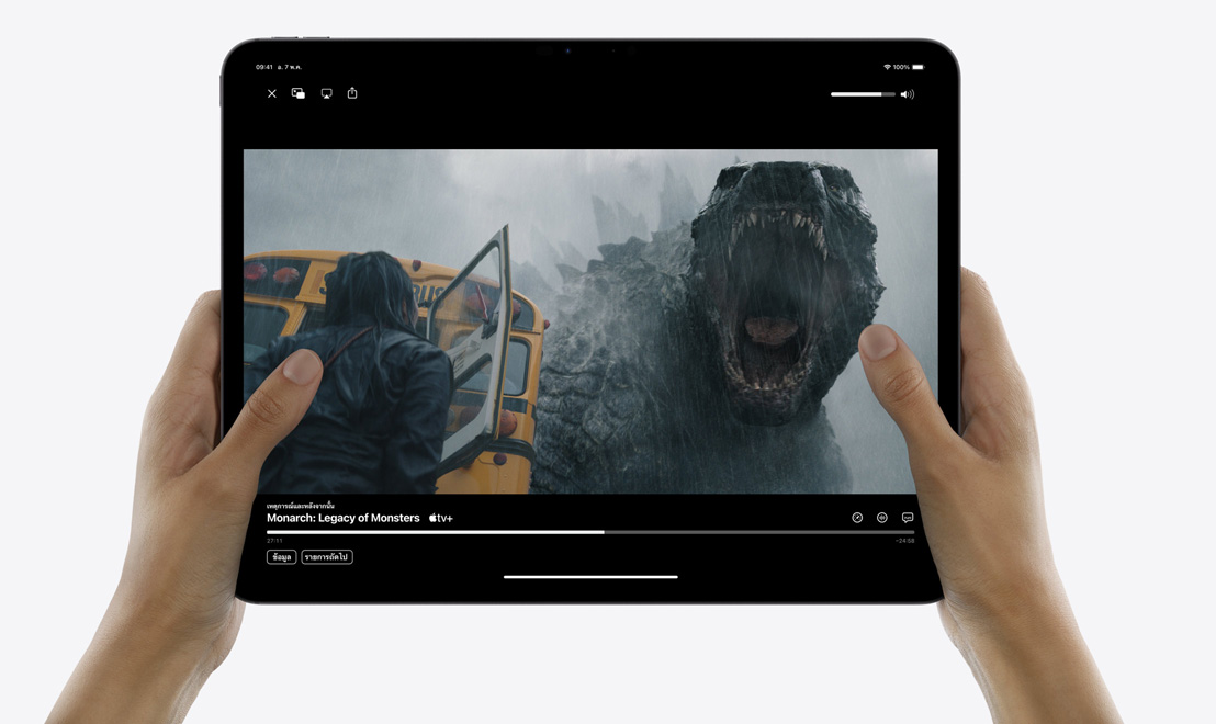 มีอคู่หนึ่งกำลังถือ iPad Pro แสดงแอป Apple TV กำลังถ่ายทอดรายการทีวี 'Monarch: Legacy of Monsters'