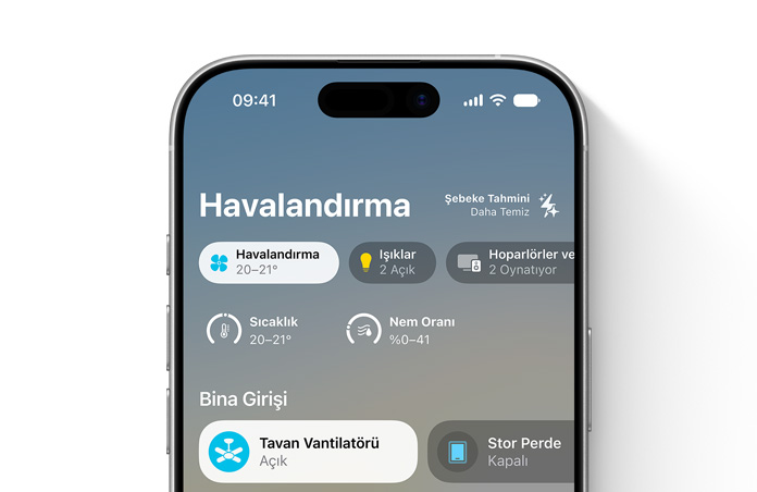 iPhone ekranında Ev uygulaması, Havalandırma kategorisi, sıcaklık ve nem kadranları gösteriliyor, Bina Girişi bölümünde tavan vantilatörü ve stor perde kontrolleri gösteriliyor