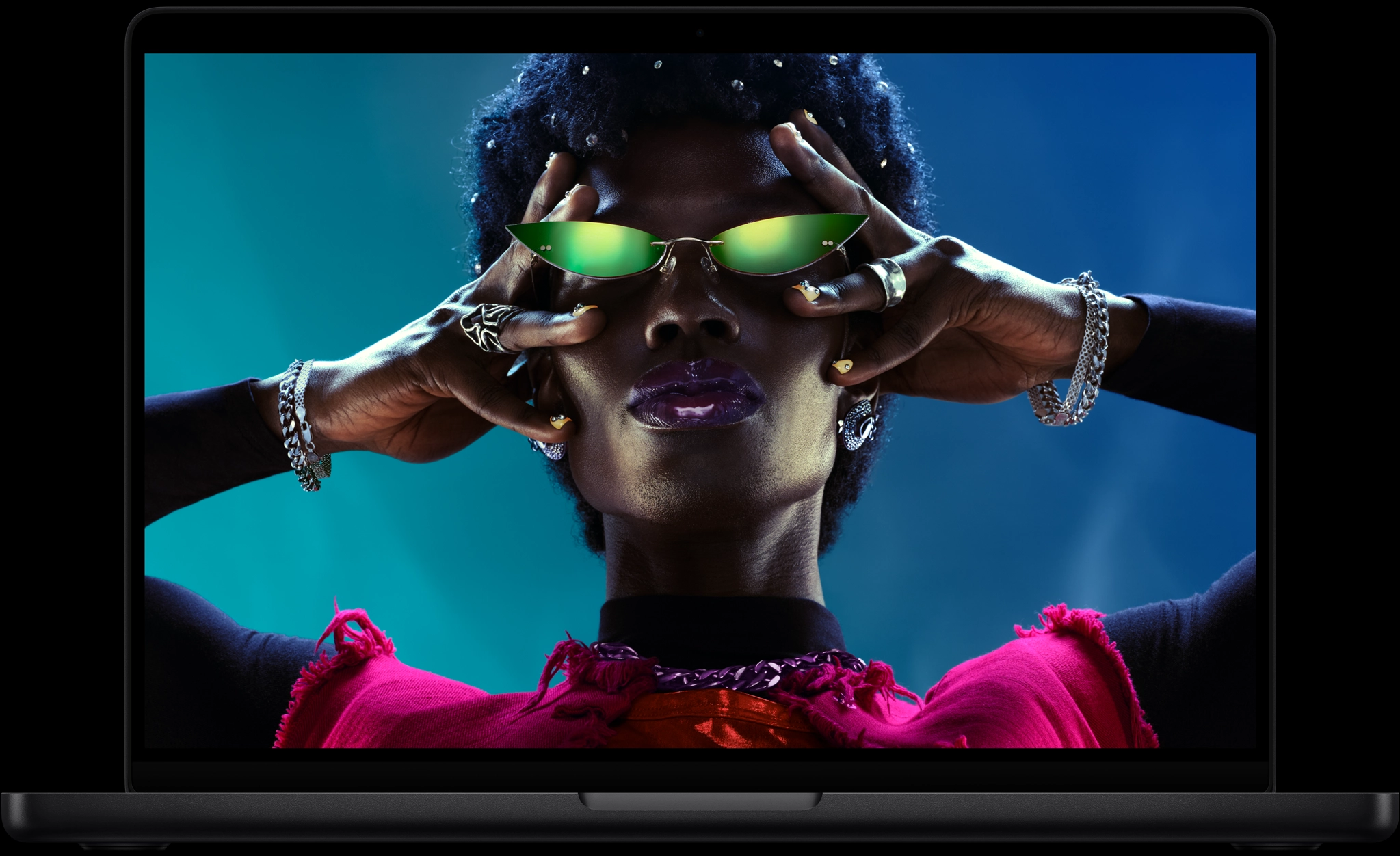 MacBook Pro 螢幕上顯示一位戴著綠色太陽眼鏡的人物特寫，展現鮮明生動的 Liquid Retina XDR 顯示器
