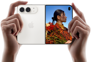 iPhone Duo, колір «біла зоря», тримають двома руками в горизонтальному положенні, розкладений; на лівій панелі видно систему двох камер Fusion 48 Мп, а на правій — людину, яку фотографують на зовнішньому дисплеї; об’єкт зйомки може бачити своє обличчя під час фотографування за допомогою режиму Duo Preview