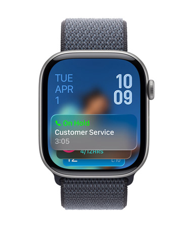 Apple Watch in Space Grey with Grey strap, Face shows Hold assist notification at bottom, date on top left, time numerals stacked at top right