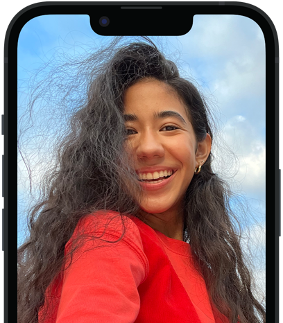 旁白功能正以英文描述 iPhone 上的照片，並以語音輸出顯示「一個穿著紅襯衫的人在多雲的藍天前擺姿勢拍照。」。
