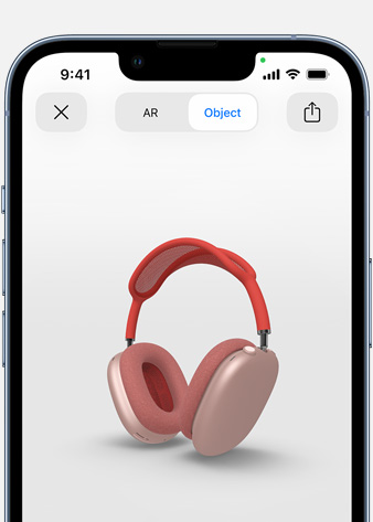 Attēlā redzamas rozā AirPods Max paplašinātās realitātes ekrānā uz iPhone.
