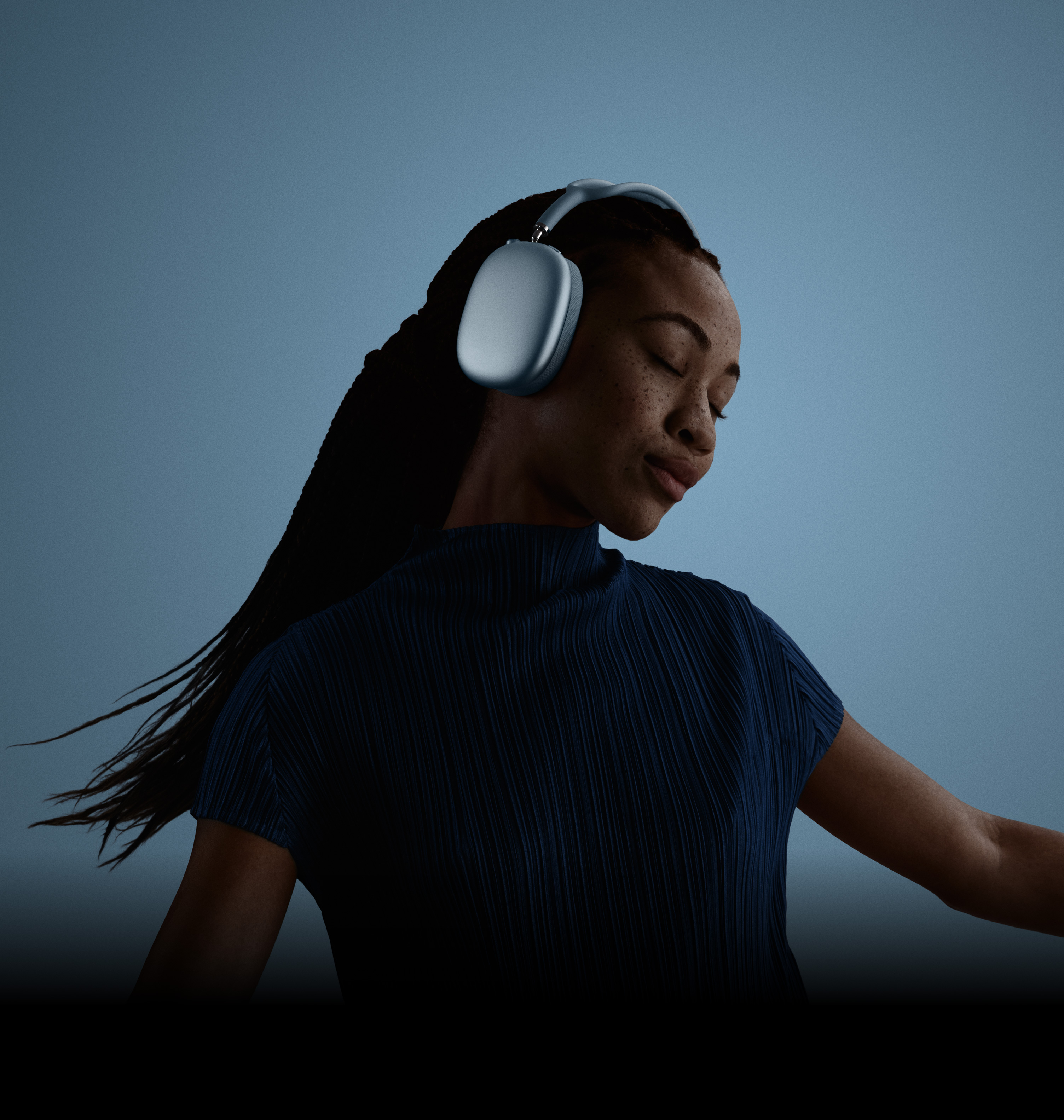 A woman with her eyes closed, and head tilted to the left, wearing AirPods Max.