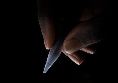 ผู้ใช้จับที่ปลายส่วนล่างประมาณหนึ่งในสามส่วนของ Apple Pencil Pro ระหว่างนิ้วหัวแม่มือและนิ้วชี้ในท่าเขียน