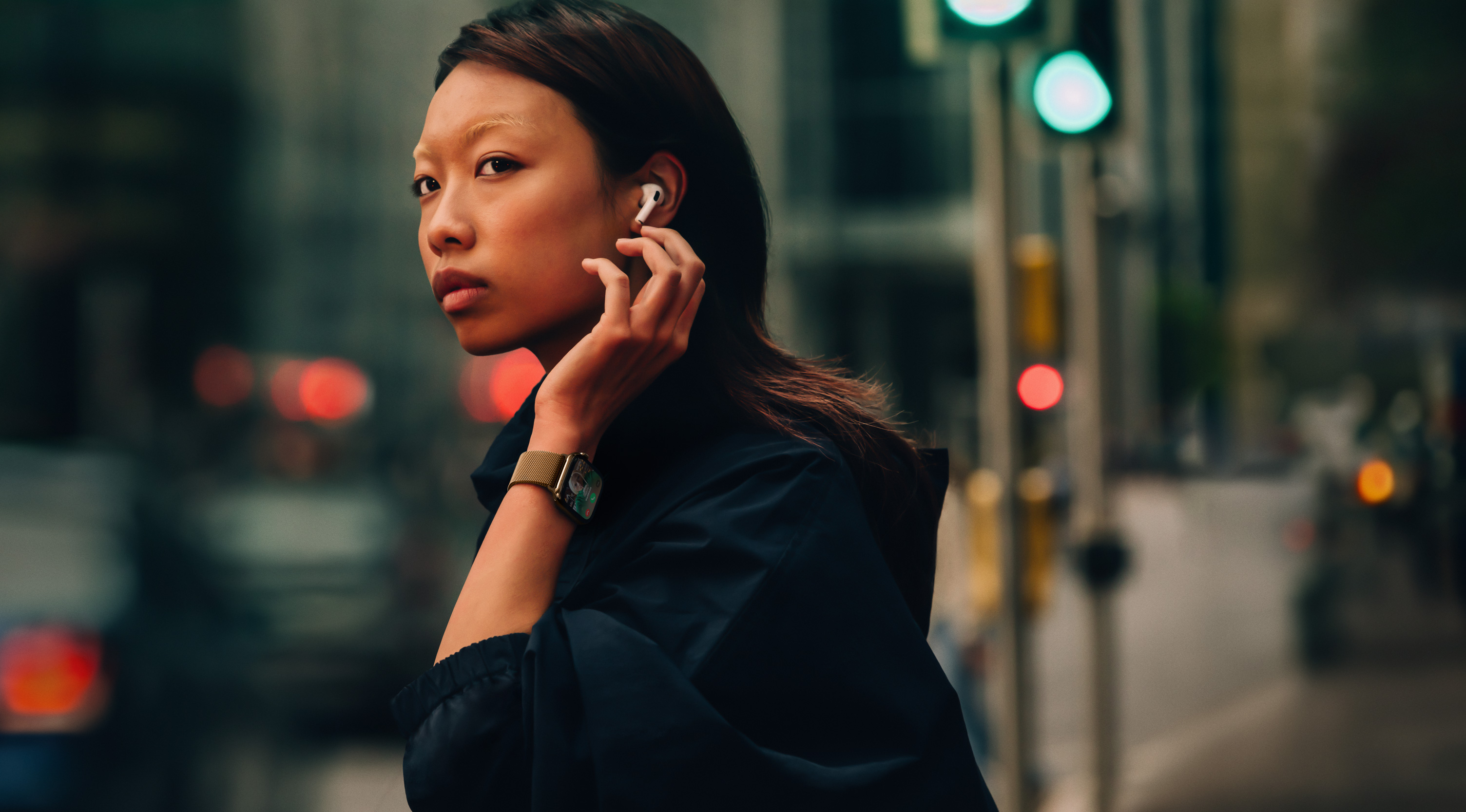 Женщина на улице в Apple Watch Series 10 и AirPods.
