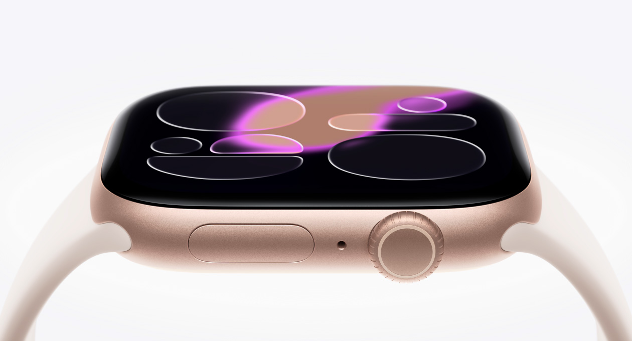 Apple Watch Series 11, rose gold colour, aluminium case, right side exterior, Ion-X strengthened glass display hovers above watch, Digital Crown, microphone, side button, convex sensor at bottom, Sport Band, light blush colour