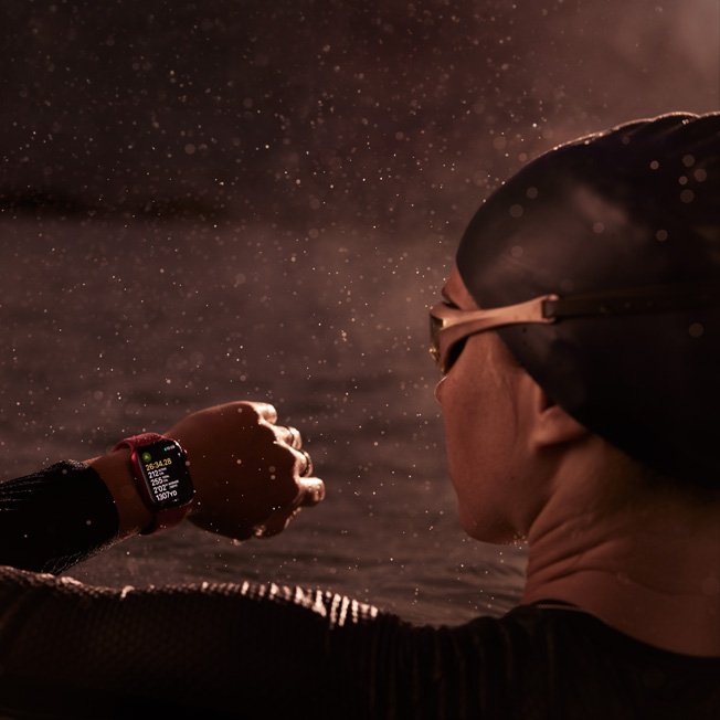 Ein Bild von einer Person, die in einem Swimmingpool schwimmt und auf ihre Apple Watch blickt.
